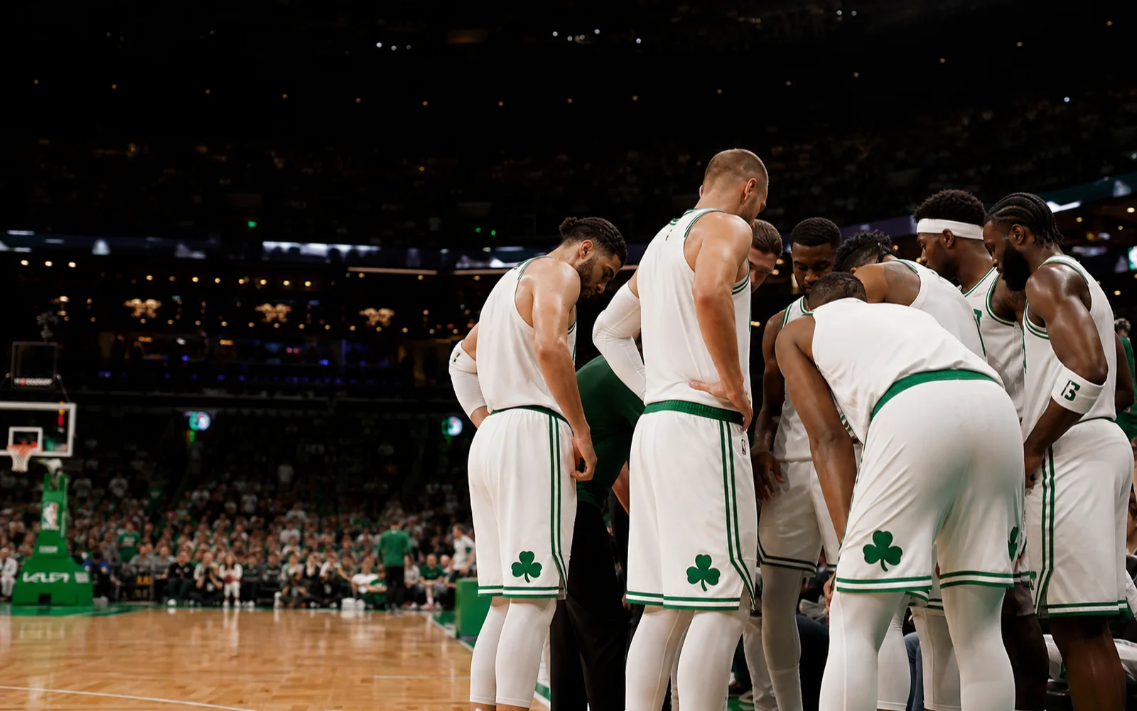 The players of an NBA team huddle on the court.